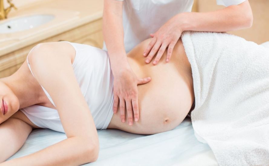 Mujer embarazada recibiendo un masaje en el estómago
